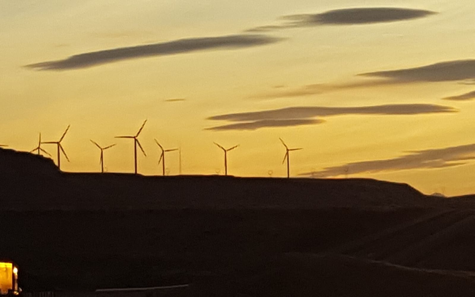 Wind turbines on a ridge at sunset